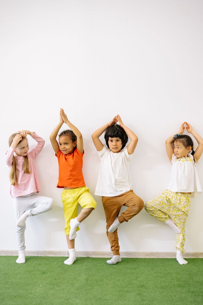 Crafting Captivating Headlines: Your awesome post title goes here Four diverse children practicing yoga indoors, promoting fun and exercise in a learning environment.